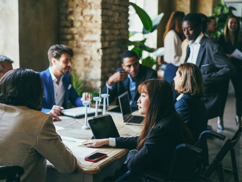 Diverse team of young professionals in a modern UAE office meeting